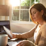 Woman drinking coffee and paying bills online