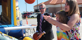 Young girl playing a carnival game with TFCU President and CEO Michael Kloiber