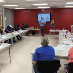 Classroom with people listening to speaker