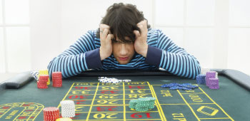 Young adult male with frustrated expression at gambling table