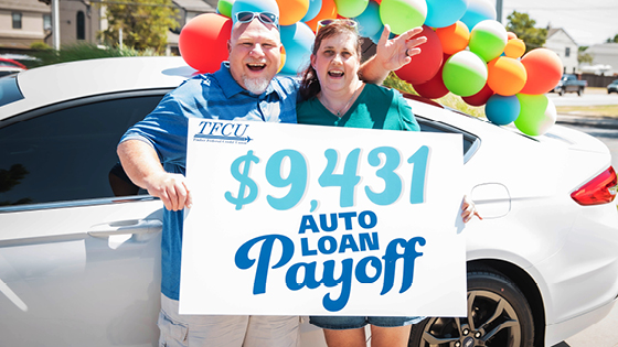 Older couple holding a great auto loan payoff winner sign
